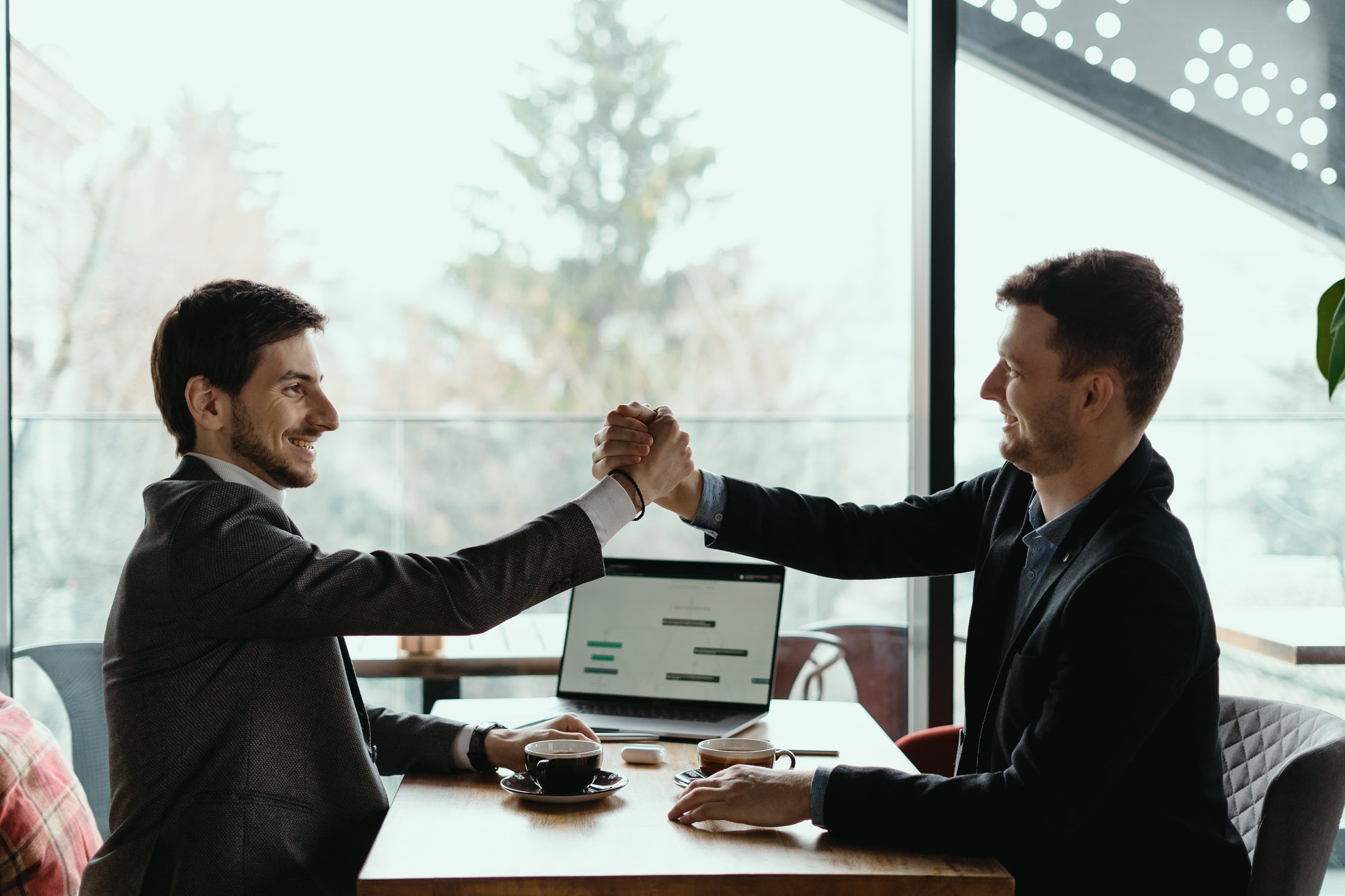two-business-men-celebrating-deal two-business-men-celebrating-deal